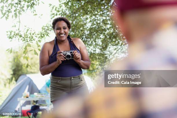 happy woman with camera at campsite - depth of field togetherness looking at the camera ストックフォトと画像