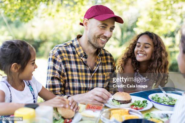 Happy father and daughters enjoying barbecue lunch