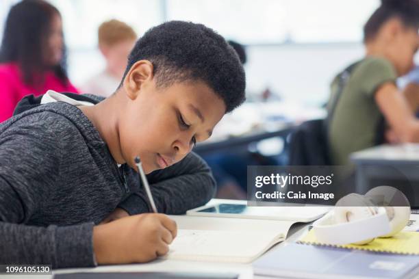 junior high school boy student doing homework in classroom - élève 12 ans photos et images de collection