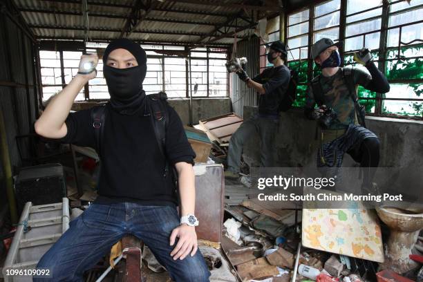 Ghost , Pripyat and Jenkins , of "Urbex" - an urban exploration group, pose for a photograph when exploring an abandoned building in Tai Kok Tsui....
