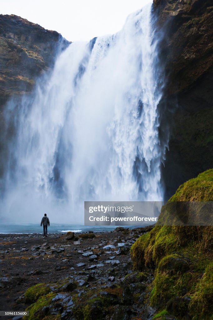 Tourist Visiting Skógafoss Waterfall at Skógar in Iceland