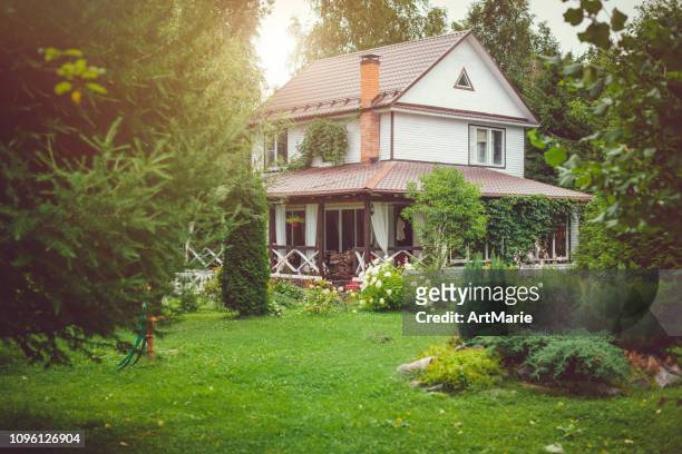 landhaus mit grünem hinterhof am sonnigen sommertag - garten baum stock-fotos und bilder