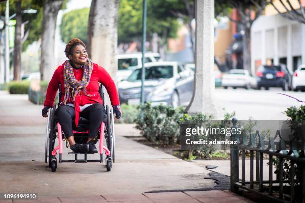 ritratto di giovane donna nera su una sedia a rotelle - accessibilità foto e immagini stock