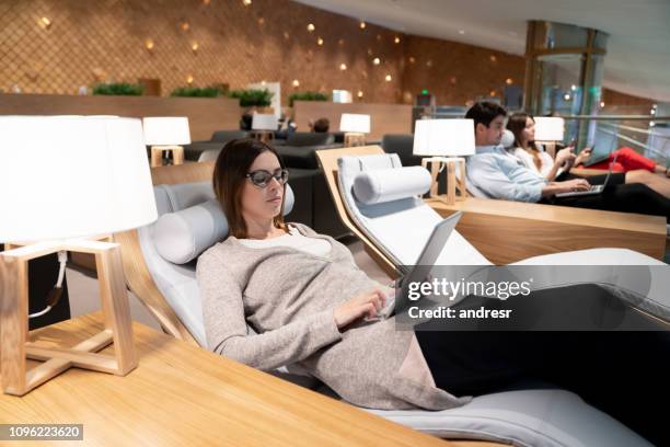 zakenvrouw ontspannen in een vip-lounge op de luchthaven reizen - vertrekhal stockfoto's en -beelden