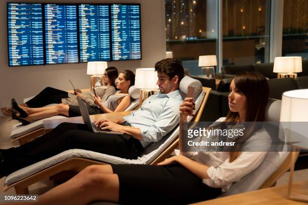 traveling business people relaxing in a vip lounge at the airport - airport business lounge stock pictures, royalty-free photos & images