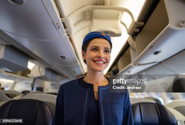 friendly flight attendant smiling on the aisle in an airplane - crew stock pictures, royalty-free photos & images