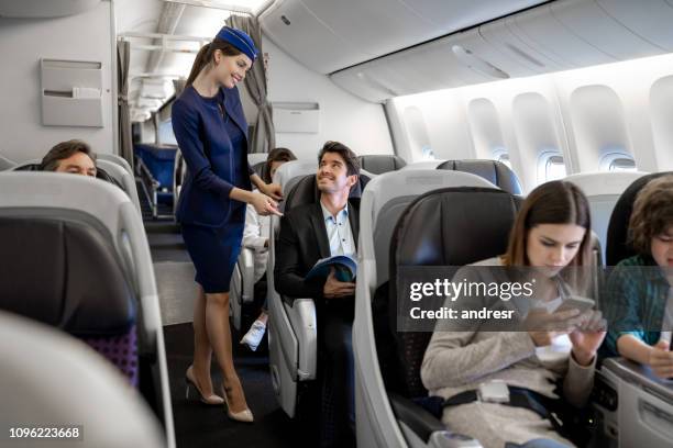 assistente di volo che controlla un uomo in aereo - hostess foto e immagini stock