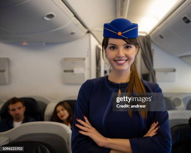 happy flight attendant smiling on the aisle of an airplane - air stewardess stock pictures, royalty-free photos & images