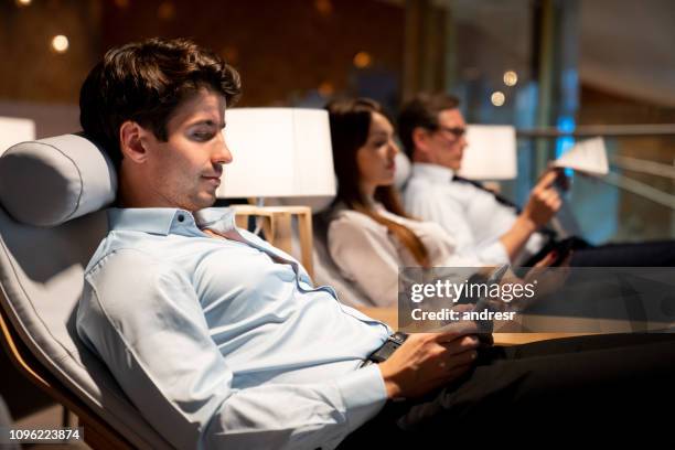 reizende zakenman ontspannen in een vip-lounge op de luchthaven - business class flight stockfoto's en -beelden