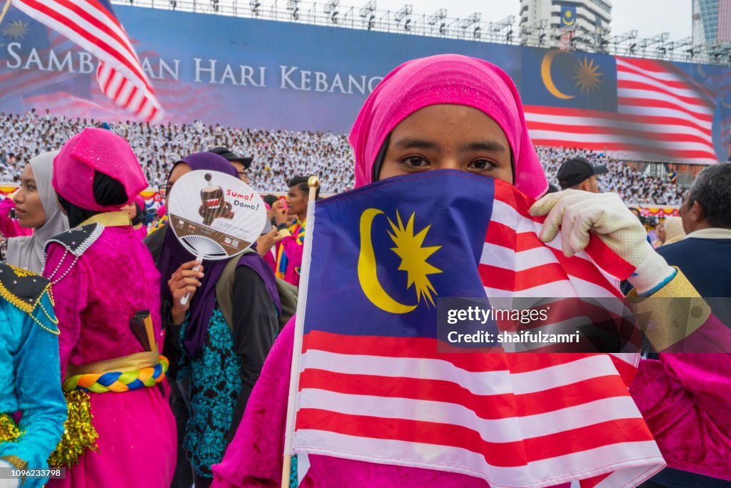 Unknown girl behind national flag of Malaysia.