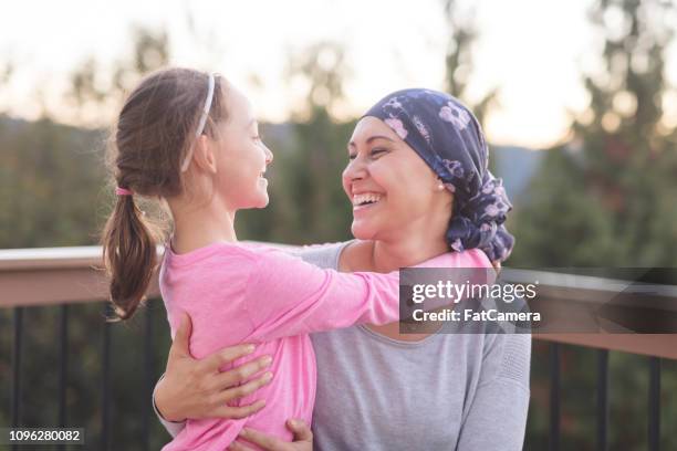 moeder met kanker knuffelen van haar dochter - cancer survivor stockfoto's en -beelden