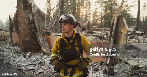 Young Firefighter Stands With Eerie Smoke-Filtered Sunlight Illuminating His Face, Surrounded by Houses Destroyed in the Paradise Wildfire 2018