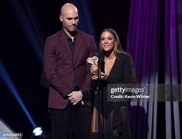 Mike Caussin and Jana Kramer receive award onstage at the 2019 iHeartRadio Podcast Awards Presented by Capital One at the iHeartRadio Theater LA on...