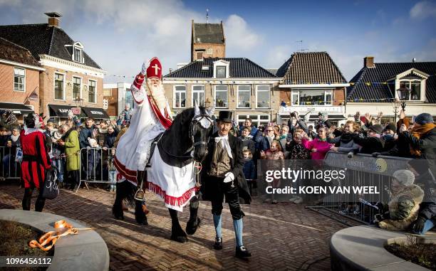 Sint Piter arrives on a horse followed by Swarte Pyt in the village of Grouw, The Netherlands, on February 9, 2019. - In the Netherlands, the annual...