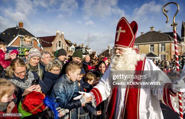 Sint Piter meets children as he arrives with Swarte Pyt in the village of Grouw, The Netherlands, on February 9, 2019. - In the Netherlands, the...