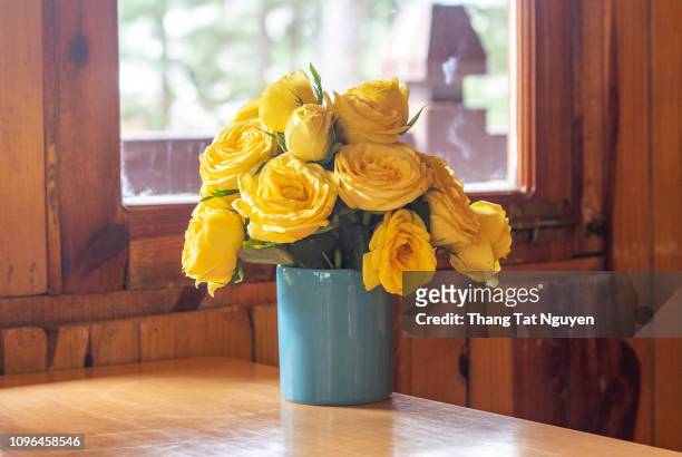 yellow rose bounquet on table by window - yellow roses stock pictures, royalty-free photos & images