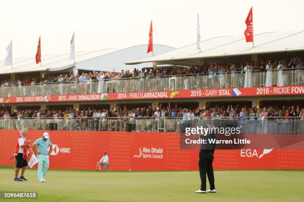 Shane Lowry of Ireland celebrates winning on the 18th green as Richard Sterne of South Africa looks on during Day Four of the Abu Dhabi HSBC Golf...