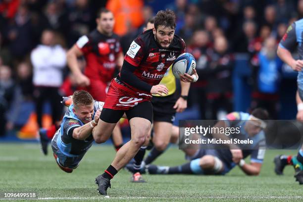 Alexis Palisson of Lyon bursts away from the challenge of Gareth Anscombe of Cardiff during the Champions Cup Pool 3 match between Cardiff Blues and...