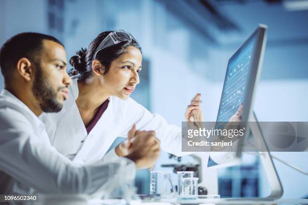 wetenschappers werken in het laboratorium - gezondheidszorg en medicijnen stockfoto's en -beelden