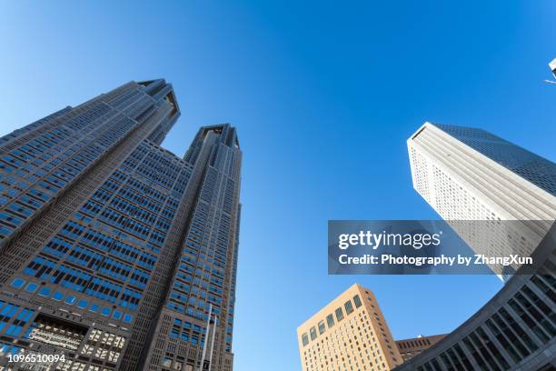 low angle view of tokyo metropolitan government building in shinjuky ward with blue sky as background, tokyo, shinjyuku, japan at day time. - tokyo metropolitan government building stock pictures, royalty-free photos & images