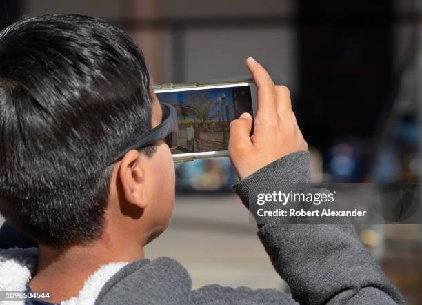 Boy takes a photograph with his smartphone in Santa Fe, New Mexico.