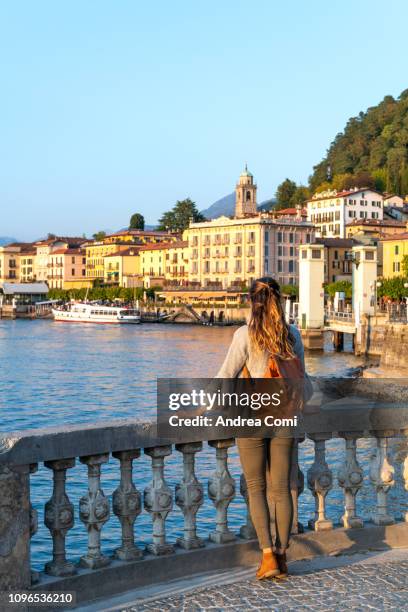 a young woman admiring the sunset from bellagio village - bellagio stockfoto's en -beelden