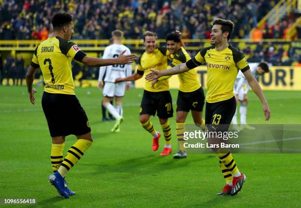 Raphael Guerreiro of Borussia Dortmund celebrates with teammate Jadon Sancho after scoring his team's third goal during the Bundesliga match between...
