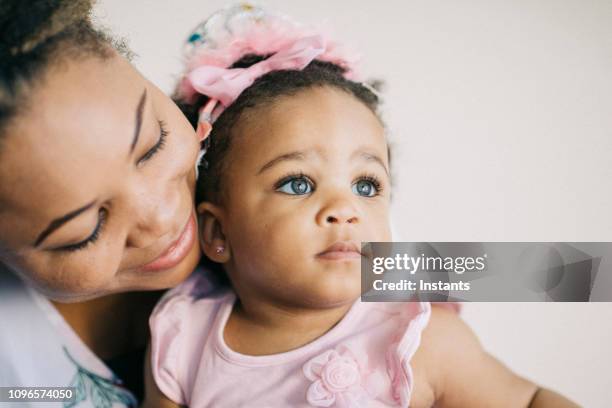 caring mother and her one year old baby girl having fun together. - ear piercing stock pictures, royalty-free photos & images