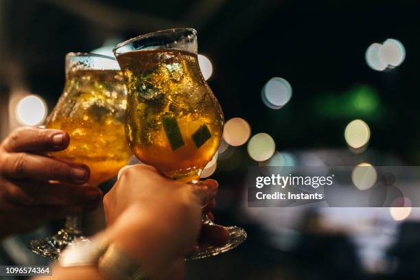 in fort de france, ein paar feiert mit jeweils einen martinican rum-cocktail in der hand. - terrasse de café stock-fotos und bilder