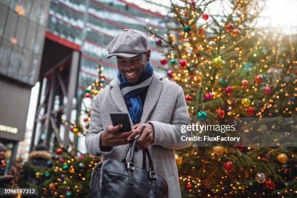 business-mann auf einer geschäftsreise scrollen seine social-media-profil während des wartens auf seinen sitzungen - christmas smartphone stock-fotos und bilder