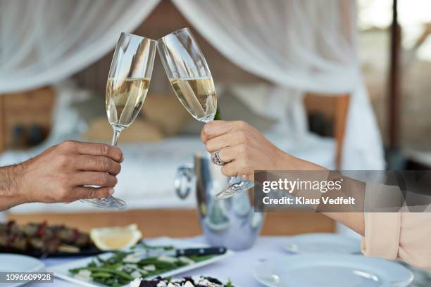 couple having private romantic dinner in luxury cabin - champagne toast stock-fotos und bilder