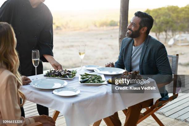 waiter serving couple at private romantic dinner in luxury cabin - couple fancy dinner stock-fotos und bilder