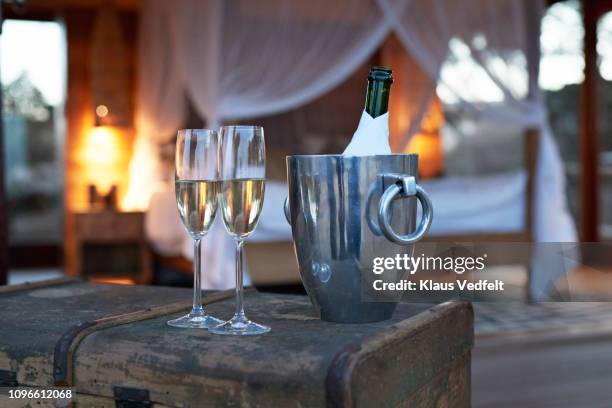 still-life of champagne glasses and bottle in front bed in exclusive cabin - portaghiaccio foto e immagini stock