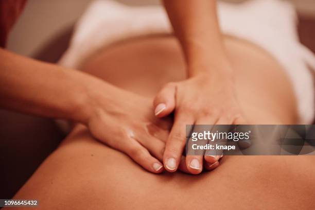 vrouw krijgt een rugmassage - masseren stockfoto's en -beelden