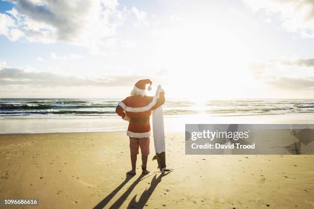 santa with surfboard. - christmas australia stock-fotos und bilder