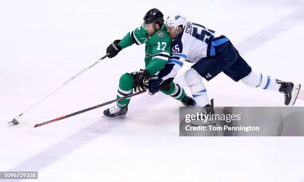 Andrew Cogliano of the Dallas Stars controls the puck against Mark Scheifele of the Winnipeg Jets in the third period at American Airlines Center on...