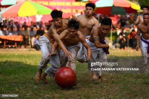 This photograph taken on February 9, 2019 shows Vietnamese men wrestling for the prized jackfruit wooden ball during the traditional "Vat Cau" or...