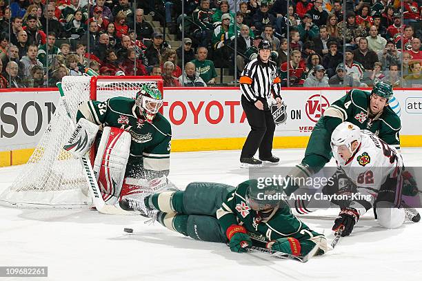 Goalie Niklas Backstrom, Matt Cullen, and Clayton Stoner of the Minnesota Wild defend their goal against Tomas Kopecky and the Chicago Blackhawks...