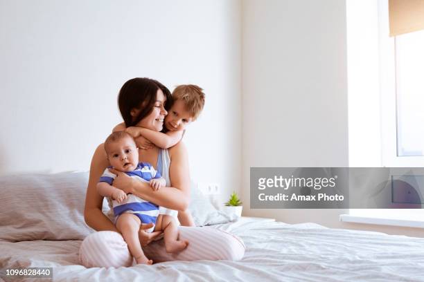portrait de mère avec deux fils dans la chambre à la maison - chambre nouveau né famille photos et images de collection