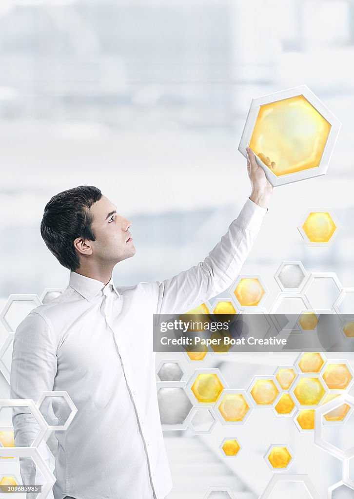 Man holding up a yellow honeycomb model