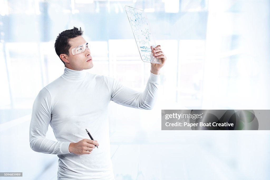 Futuristic man looking at a board with DNA codes