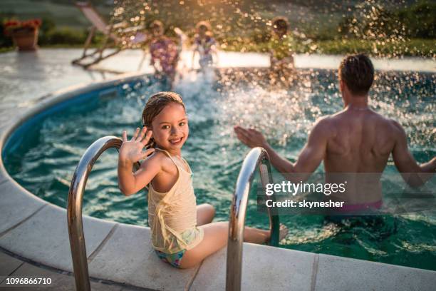 happy little girl waving at the poolside. - family waving stock pictures, royalty-free photos & images