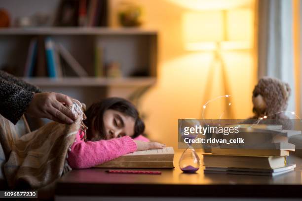 adorable niña durmiendo sobre una pila de libros - hourglass books fotografías e imágenes de stock