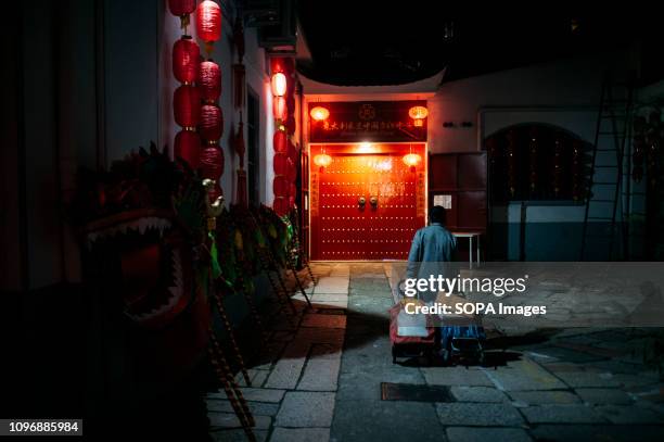 Lady is walking to the entrance of the Chinese Cultural Center in the run up to Chinese New Year in Via Sarpi, Milans Chinatown, one of the oldest in...