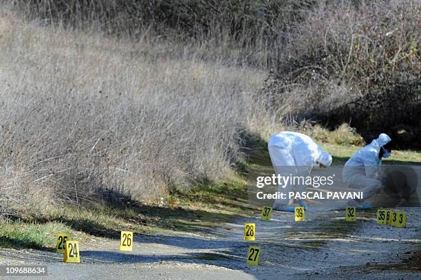 Des experts de la brigade scientifique examinent des traces sur un chemin de la commune de Bouloc, le 15 février 2011, où des effets personnels de...