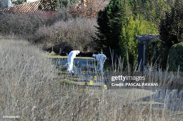 Des experts de la brigade scientifique examinent des traces sur un chemin de la commune de Bouloc, le 15 février 2011, où des effets personnels de...