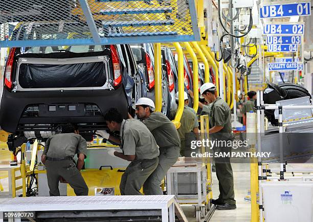 Assembly line workers, working on the "world's cheapest car" the Tata Nano, are seen at the new Nano plant at Sanand, some 40 kms. From Ahmedabad, on...