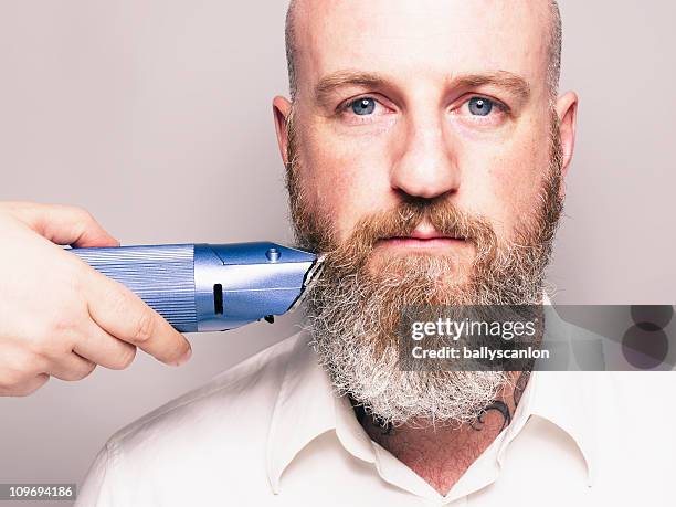 bearded man with hair clippers.  portrait. - electric razor stock pictures, royalty-free photos & images