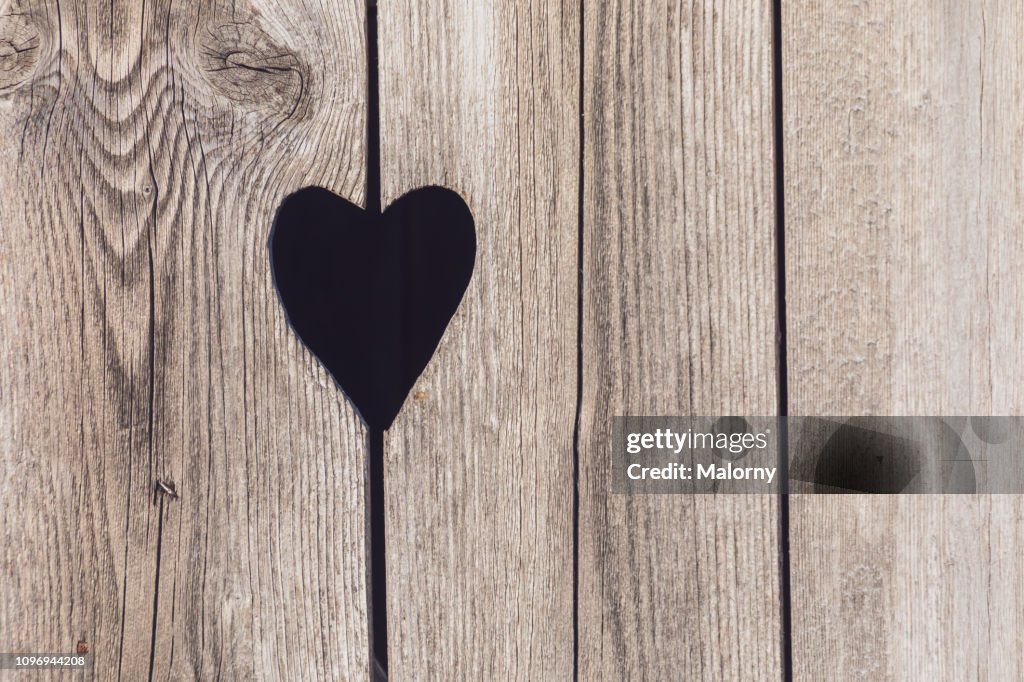 Close-up of heart shape on wooden door.