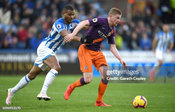 Steve Mounie of Huddersfield chases down Kevin De Bruyne of Manchester City during the Premier League match between Huddersfield Town and Manchester...